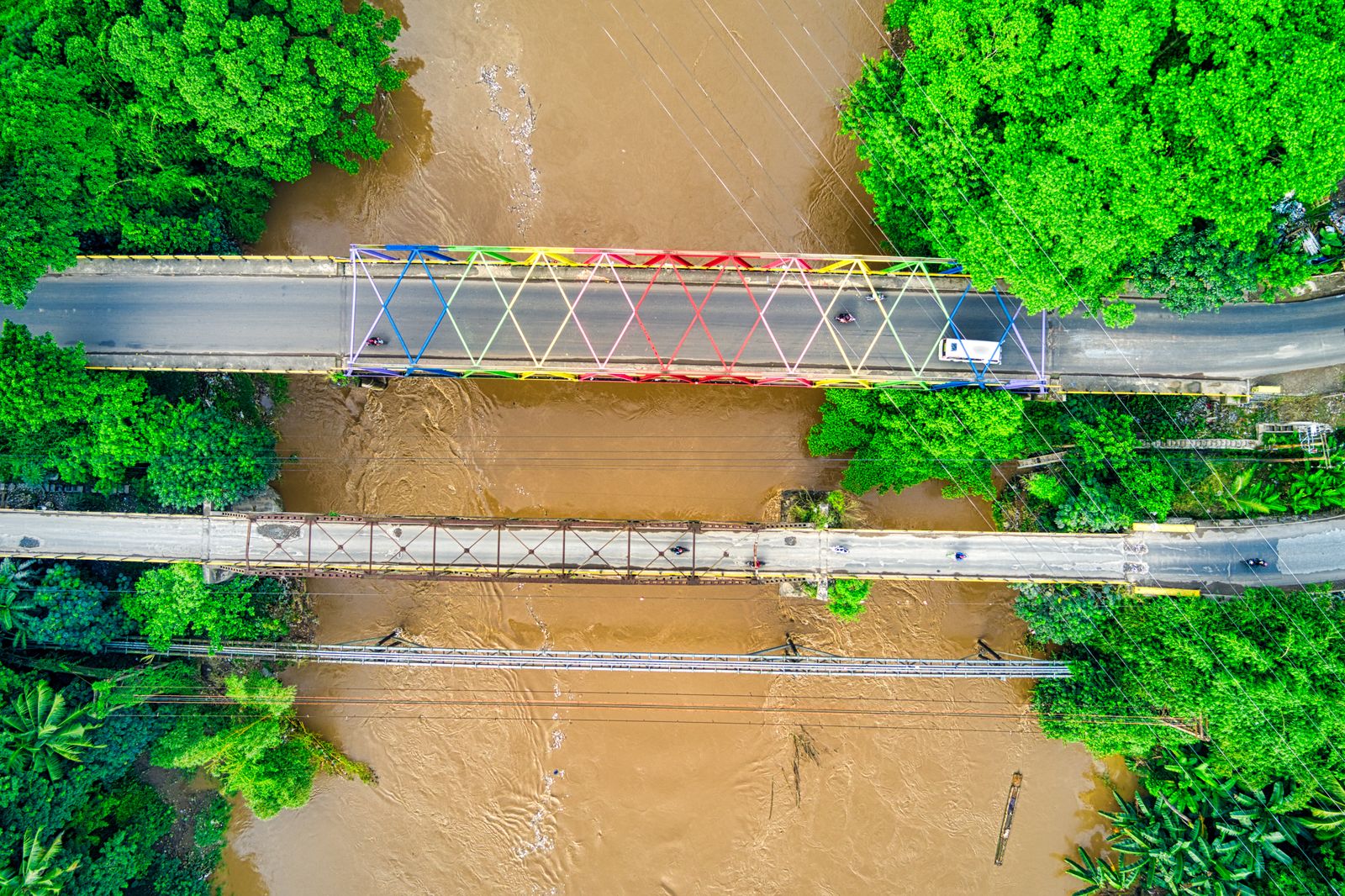 Aerial view of a bridge over a river swollen with murky brown floodwater