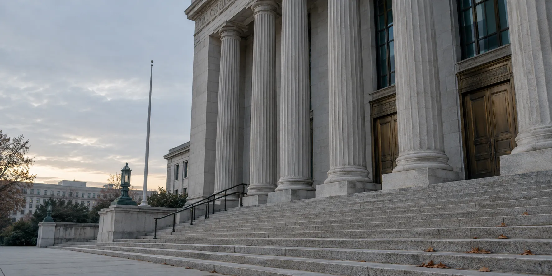 The stone steps and columns of a federal courthouse in early morning, empty.